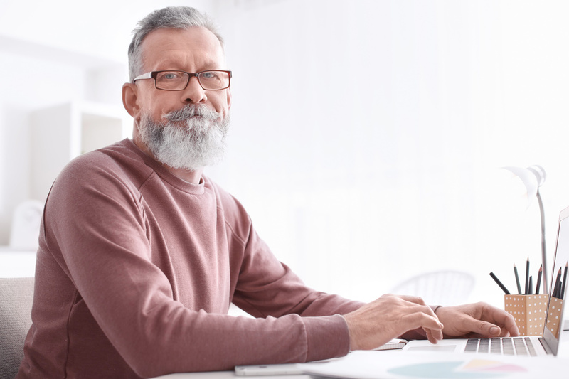 Old Bearded Man Working with His Laptop